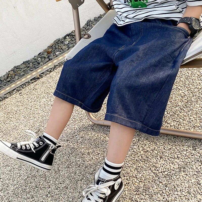 child playing outdoors wearing denim shorts
